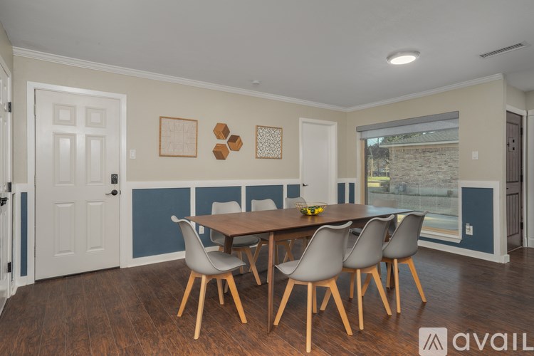 A dining room with a table and chairs.
