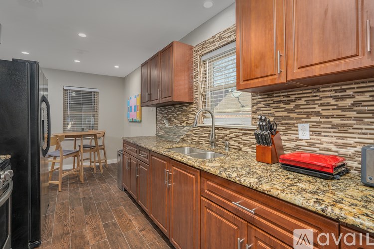A kitchen with wooden cabinets and a granite countertop.