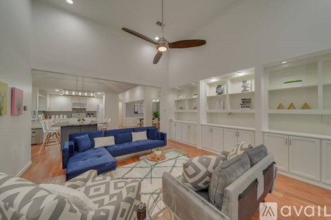 A living room with a blue couch and a fan.