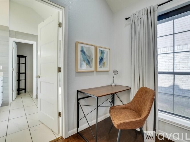 A room with a chair, a table, and a painting on the wall.