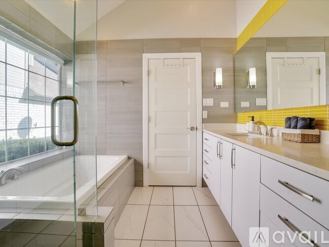 A bathroom with a glass shower door and white tiles.