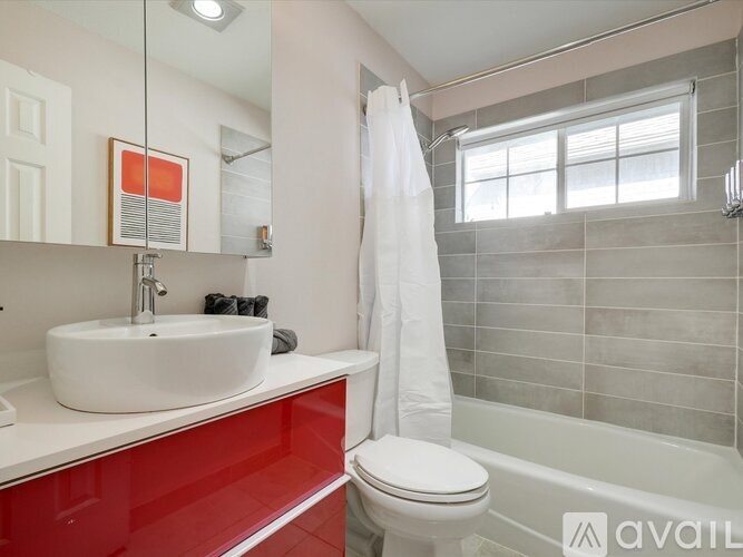 A white sink is on a counter with red tiles.