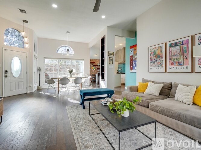 A living room with a couch, coffee table, and a large window.