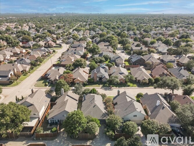 A bird's eye view of a suburban neighborhood with houses and trees.