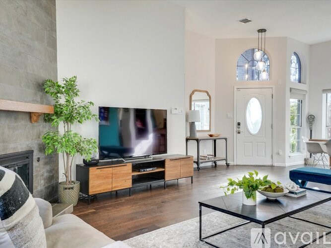 A living room with a fireplace and a television.