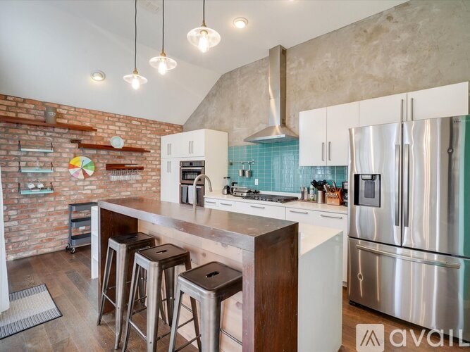 A kitchen with a brick wall and stainless steel appliances.