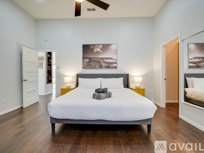 A bedroom with a large bed and a ceiling fan.