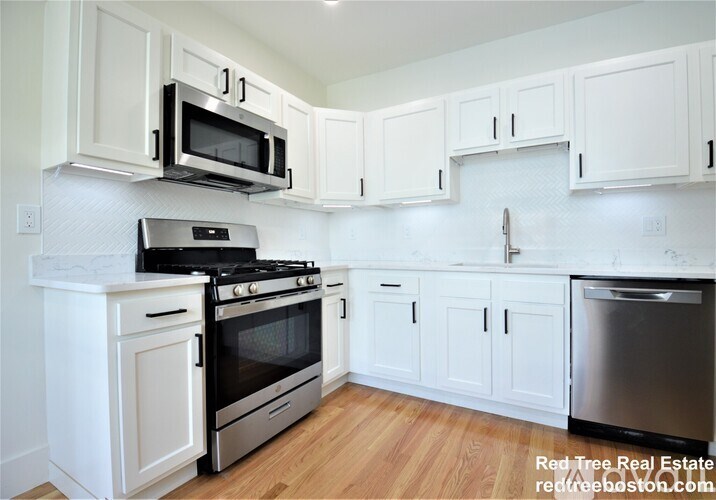 A kitchen with white cabinets and appliances.