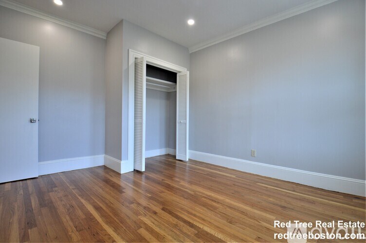 A room with wooden floors and a white door.