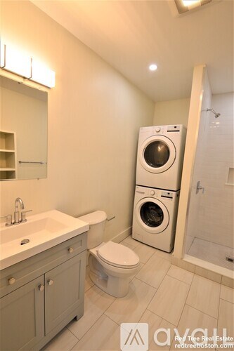 A small bathroom with a washer and dryer built into the cabinet.
