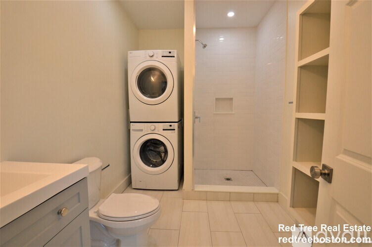 A white washer and dryer in a small bathroom.