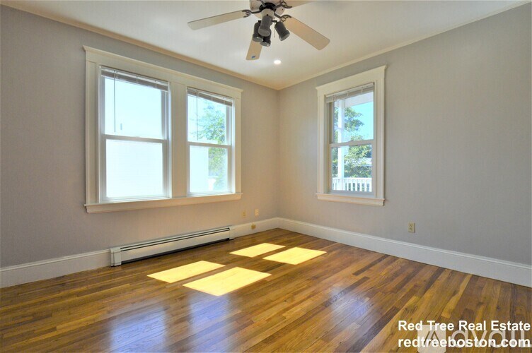 A room with wooden floors and a ceiling fan.