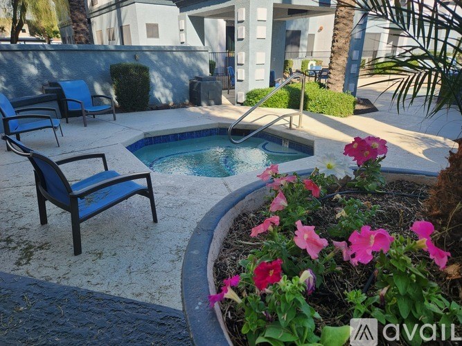 A pool surrounded by chairs and flowers.