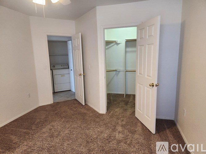 A carpeted room with a doorway leading to another room.