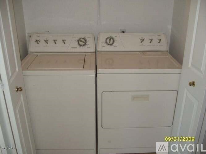 A white washer and dryer are in a small cabinet.