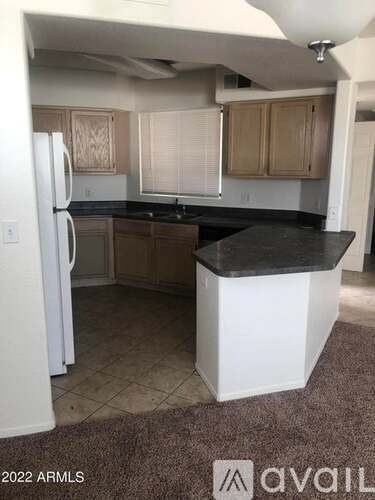 A kitchen with a white refrigerator and wooden cabinets.