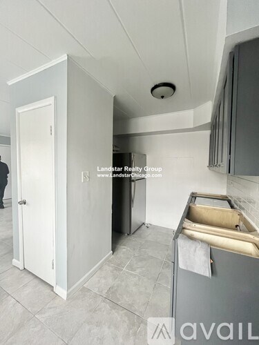 A kitchen with a white door and a black fridge.