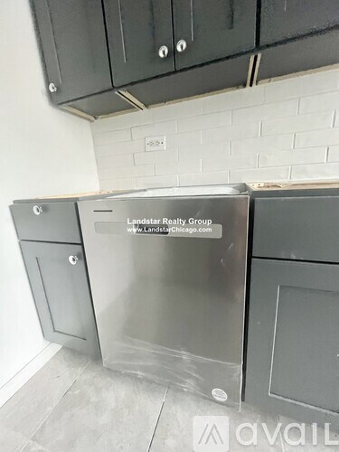 A kitchen with a stainless steel dishwasher and a website address on it.