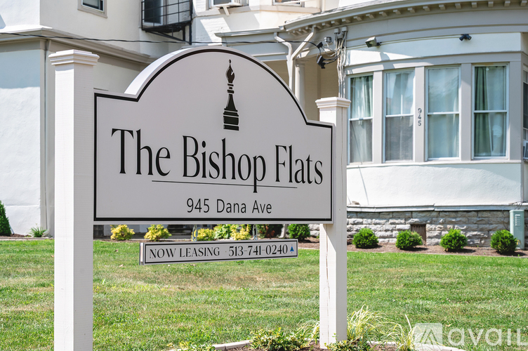 A large white house with a brown roof and a sign that says "The Brick Flats".