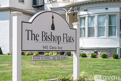 A large white house with a brown roof and a sign that says "The Brick Flats".