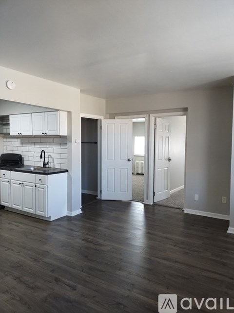 A kitchen with white cabinets and a black countertop.