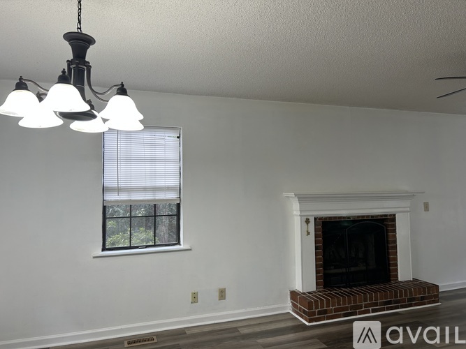 A room with a fireplace and a window with blinds.