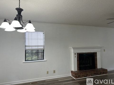 A room with a fireplace and a window with blinds.