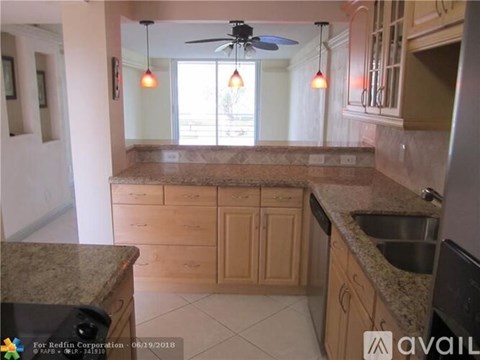 A kitchen with wooden cabinets and a granite countertop.