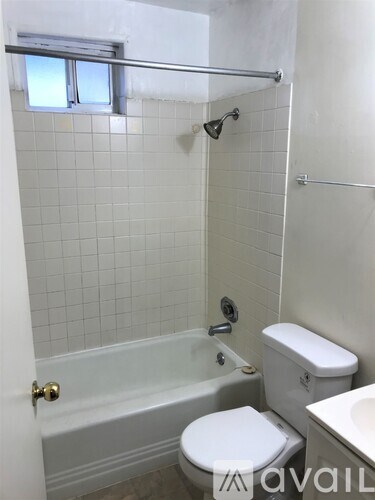 A white toilet sits next to a bathtub in a bathroom.