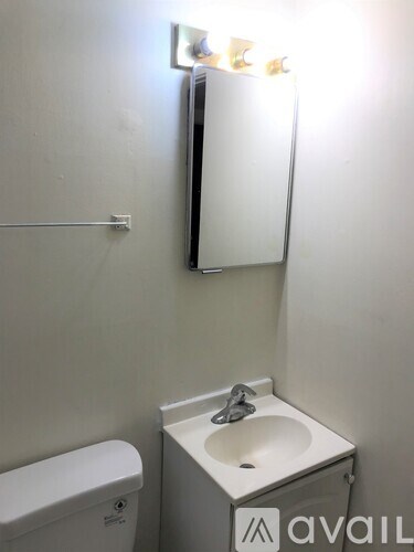 A small bathroom with a toilet, sink and mirror.