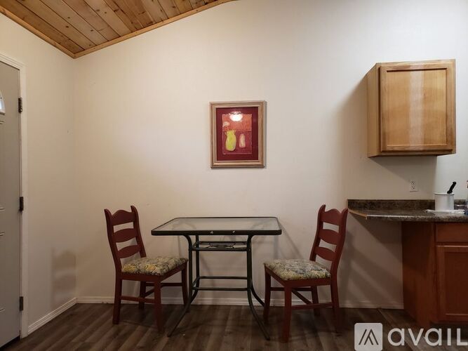 A dining room with a table and two chairs.