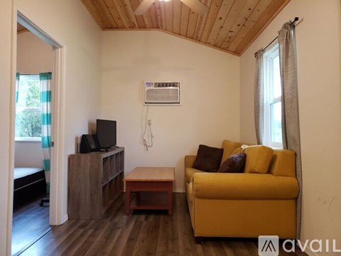 A living room with a yellow couch and a wooden coffee table.