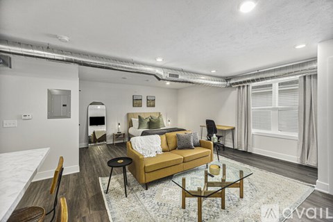 A living room with a sofa, a coffee table, and a dining table.