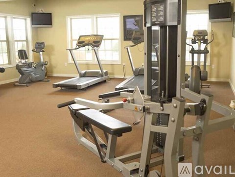 A gym with treadmills, elliptical machines, and a weight machine.