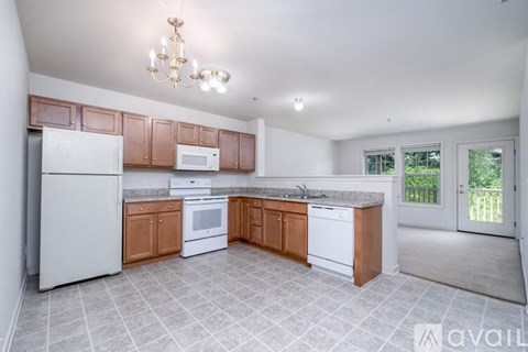 A kitchen with white appliances and wooden cabinets.