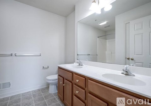 A bathroom with a toilet, sink, and mirror.