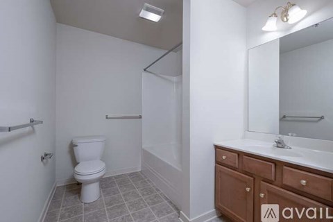 A bathroom with a toilet, sink, and mirror.
