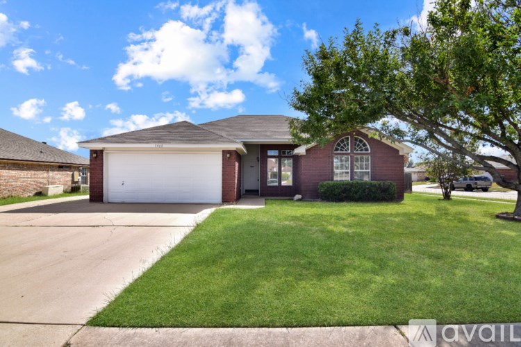 A house with a garage and a driveway in front of it.