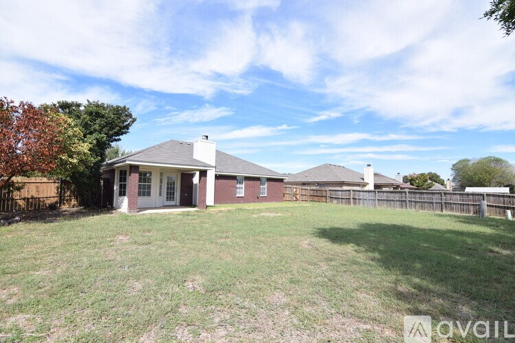 A house with a fence and a tree in front of it.