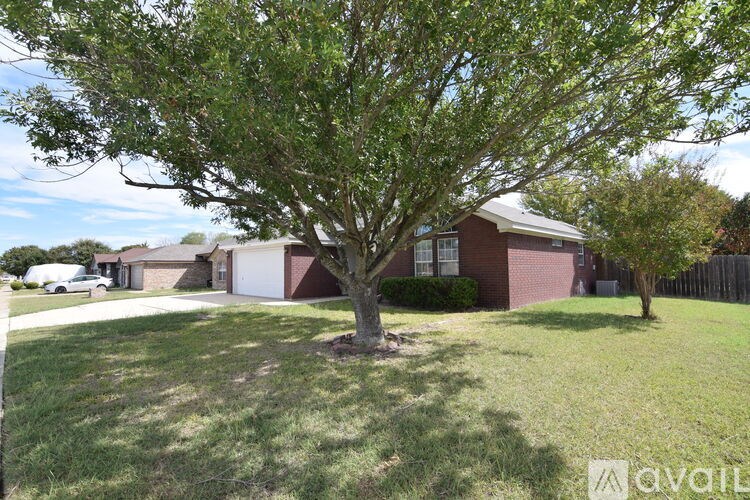 A tree in a yard in front of a house.