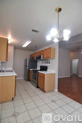 A kitchen with wooden cabinets and a tile floor.