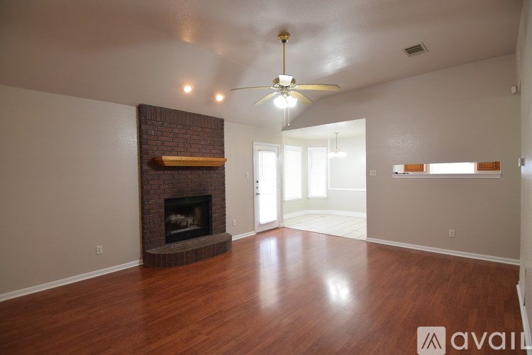 A living room with a fireplace and a ceiling fan.