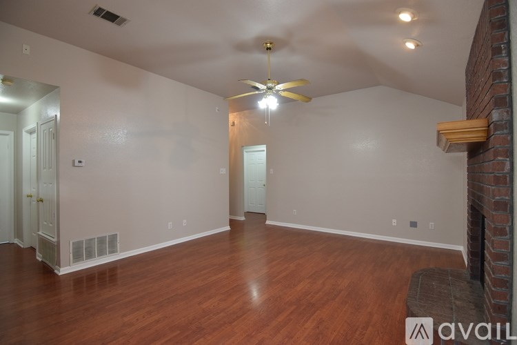 A room with a ceiling fan and wooden flooring.