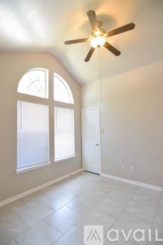 A room with a ceiling fan and a window.