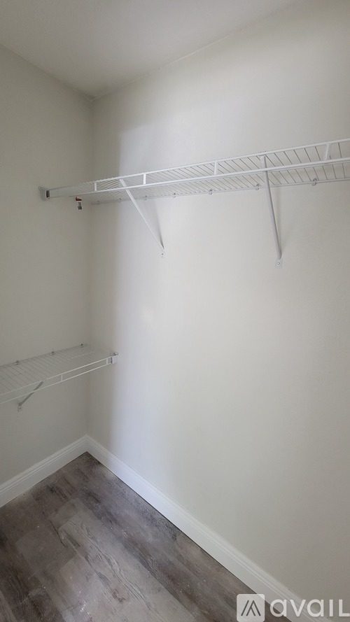 A white wall with a white shelf on it.