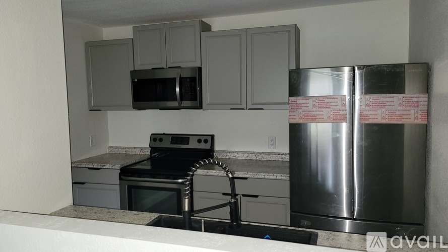 A kitchen with a stove, microwave, and oven.