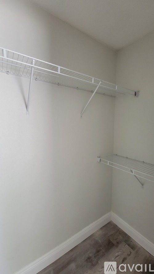 A white wall with a metal shelf attached to it.