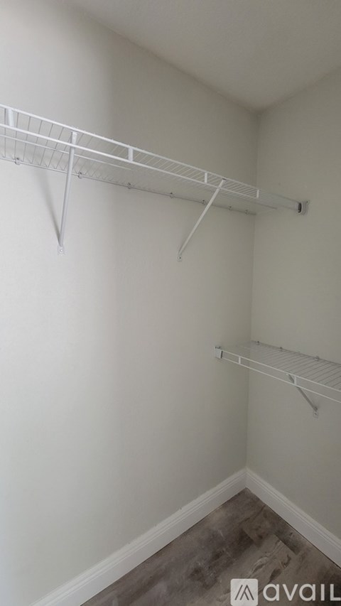 A white wall with a metal shelf attached to it.