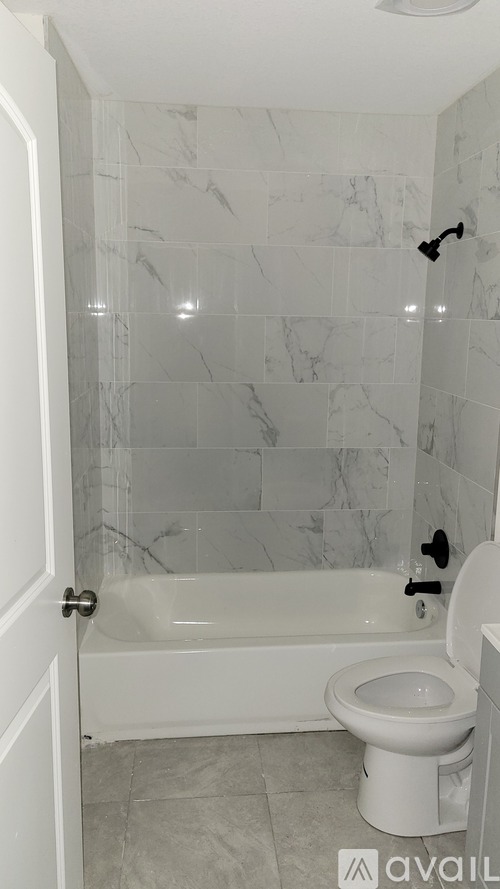 A white toilet sits next to a bathtub in a bathroom.
