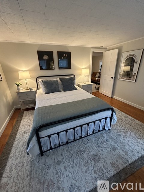 A bedroom with a large bed and a carpeted floor.